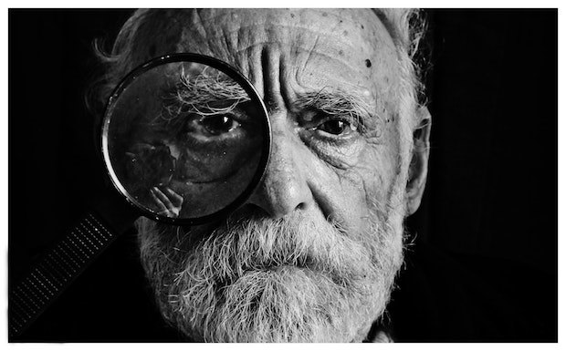 an older man with a magnifying glass over his eye